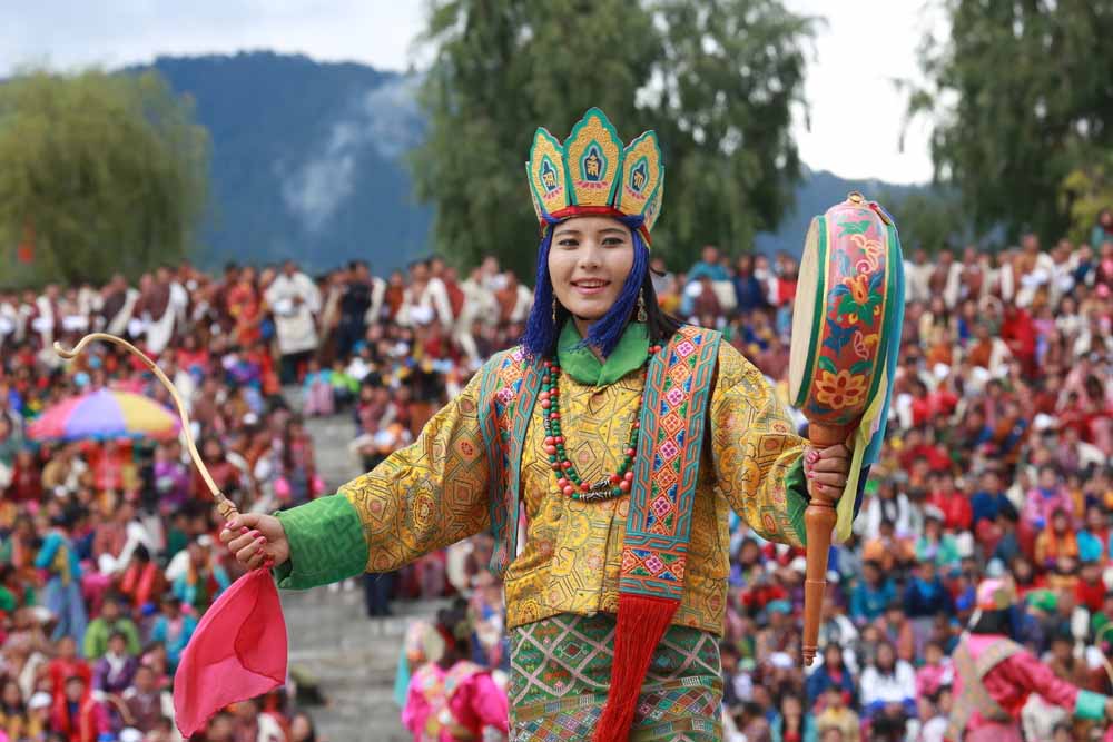 Vibrant dancers in traditional attire celebrating Tshechu, the epitome of Bhutan's rich cultural festivals.
